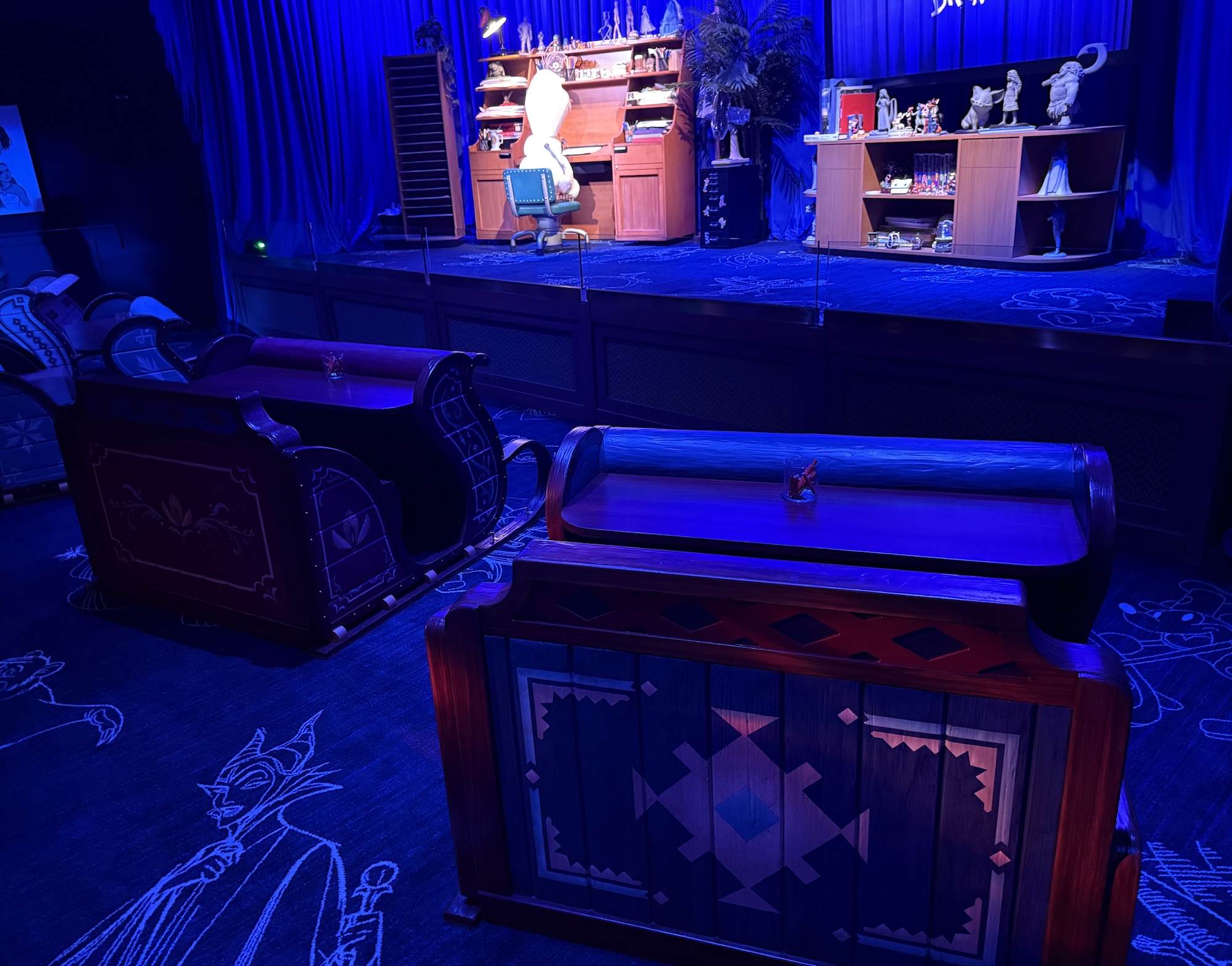 A look at the Disney drawing class room that has Olaf working at a desk on stage and the front row seats are small sleds.