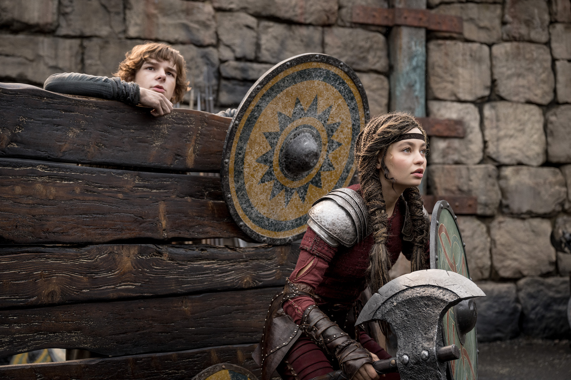 Astrid and Hiccup learning to tame dragons in the ring with Viking gear on.