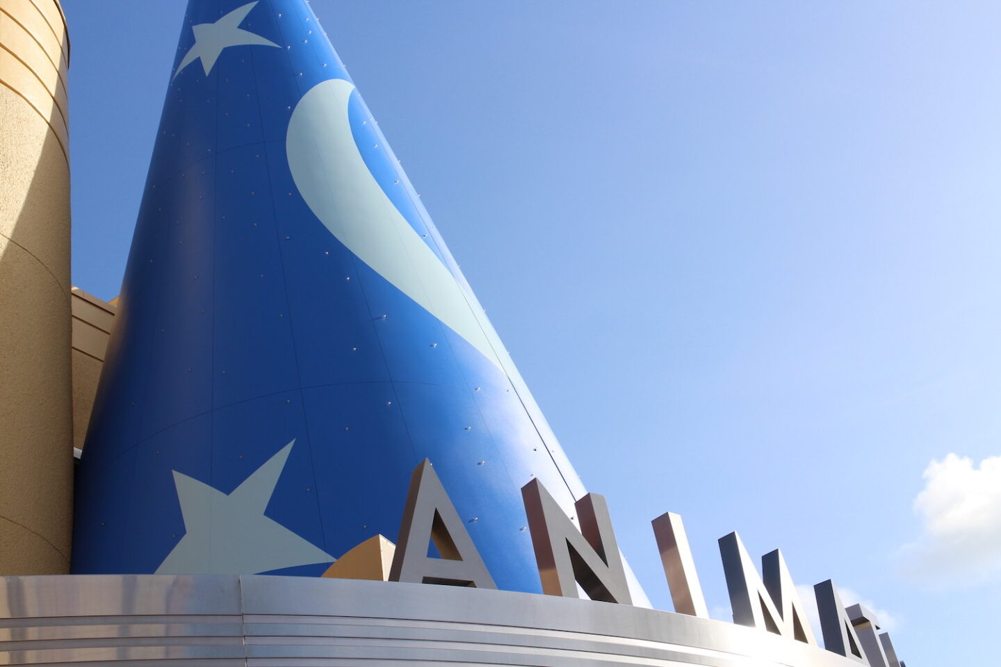 Mickey Mouse's blue Sorcerer Hat from Fantasia sits on a building with silver letters Animation peeking out.